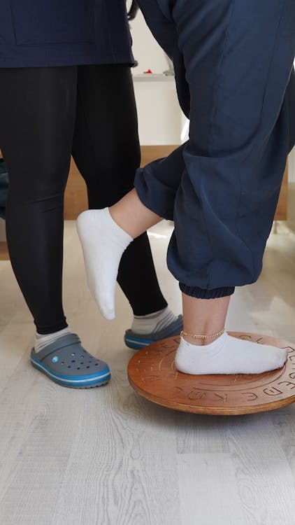 Adult performing a supported balance exercise for vestibular rehabilitation